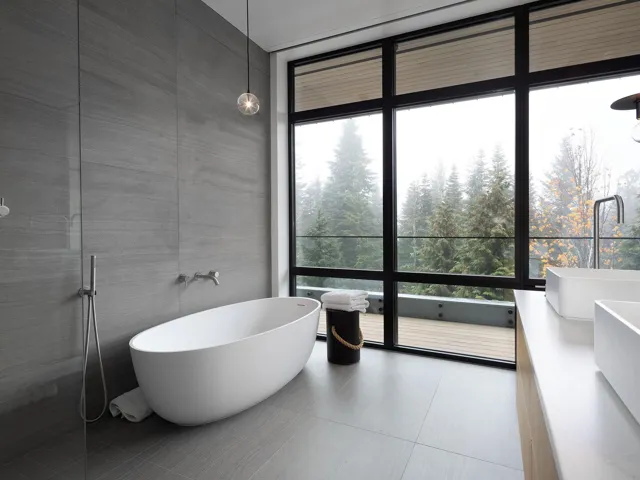 Full bathroom featuring a wall of windows, double vanity, and a soaking tub