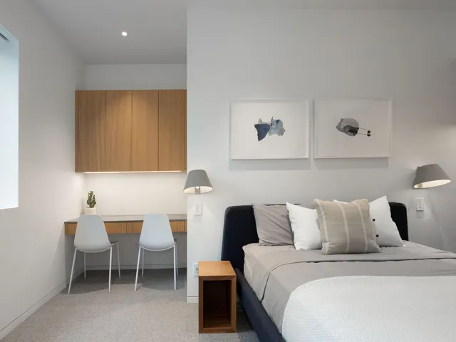 Bedroom featuring light colored carpet and built in study area