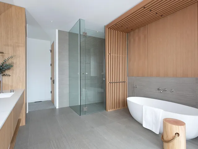 Bathroom with a freestanding tub, a stall shower, vanity, and tile walls