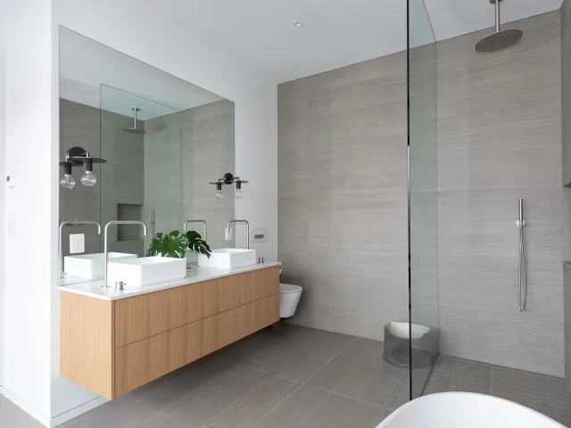 Full bathroom featuring walk in shower, double vanity, tile patterned flooring, and tile walls