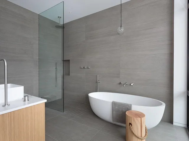 Full bathroom with vanity, walk in shower, a freestanding tub, and tile walls