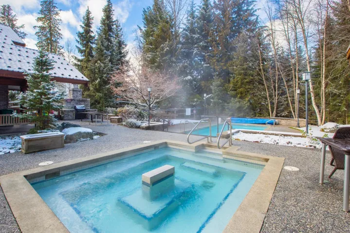 Pool featuring an outdoor stone fireplace, a patio, and an in ground hot tub