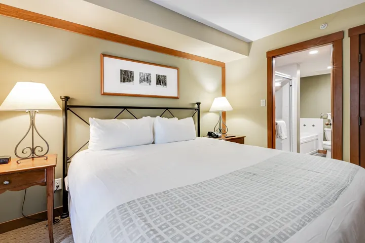 Bedroom with connected bathroom and baseboards