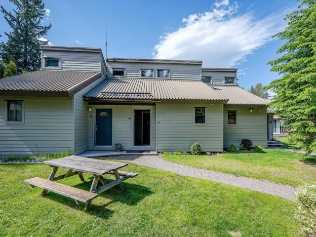 Rear view of property featuring a lawn and metal roof