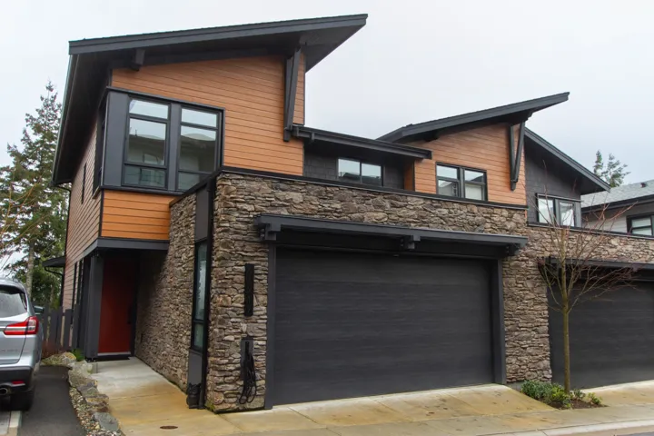 Contemporary home with stone siding and a garage