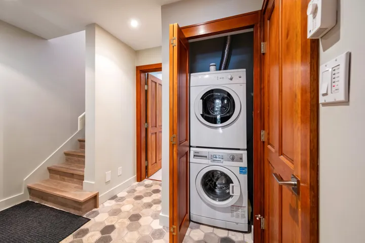 Laundry area featuring stacked washer and clothes dryer and recessed lighting