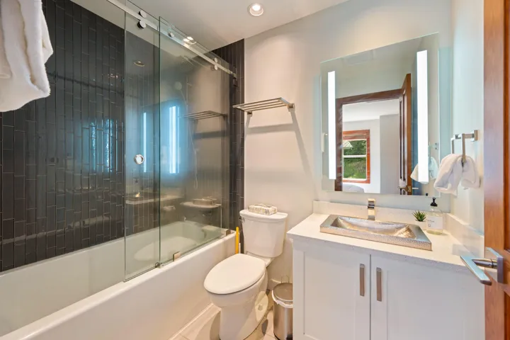 Bathroom featuring vanity, shower / bath combination with glass door, and recessed lighting