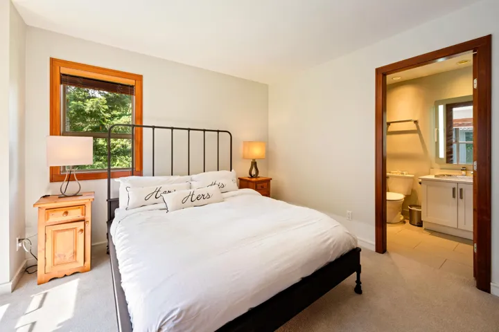 Bedroom with light colored carpet and ensuite bath