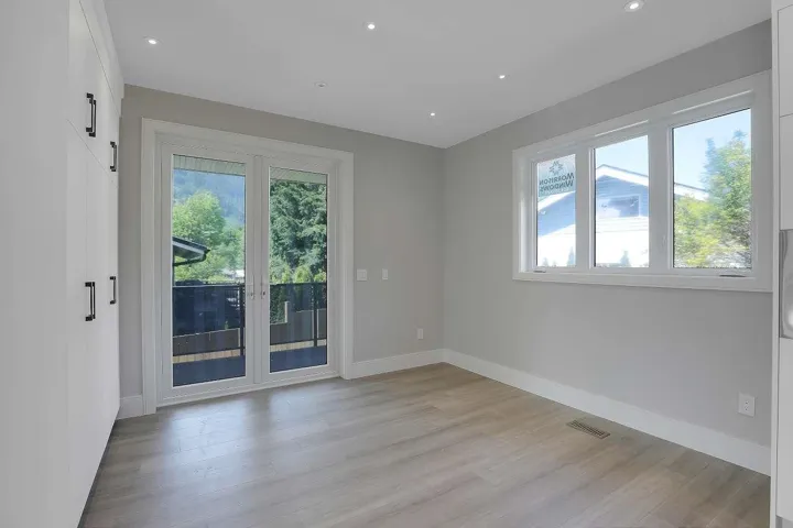 Empty room with light wood-style floors and recessed lighting