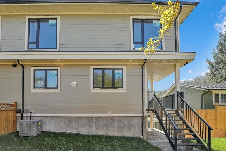 View of side of property featuring stairway and a cooling unit