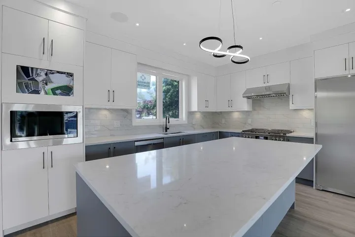 Kitchen with white cabinets and light stone counters