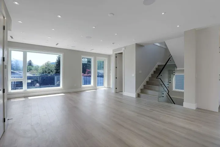 Unfurnished living room with light wood-style flooring, recessed lighting, and stairs
