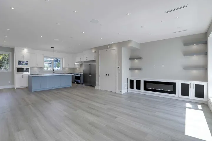 Unfurnished living room featuring light wood-style flooring, recessed lighting, and a glass covered fireplace