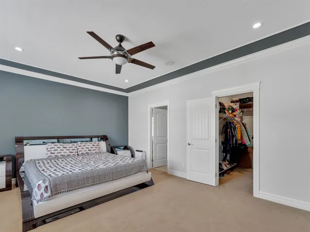 Room featuring a tray ceiling with crown molding, recessed lighting, and a ceiling fan