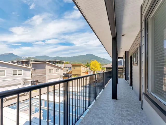 Covered balcony featuring a black metal railing and grey textured flooring