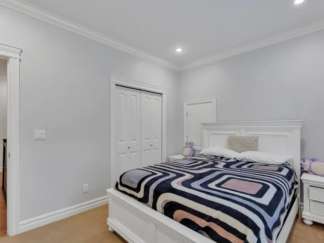 Bedroom featuring recessed lighting, crown molding, white trim, and a bi-fold closet door