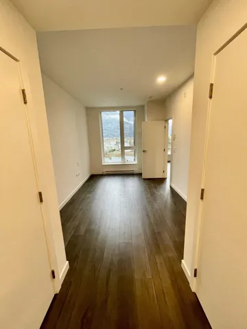 Unfurnished living room with dark wood finished floors and baseboard heating