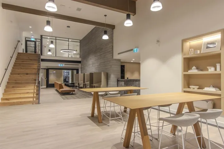 Dining room with a towering ceiling, wood finished floors, stairs, and beamed ceiling