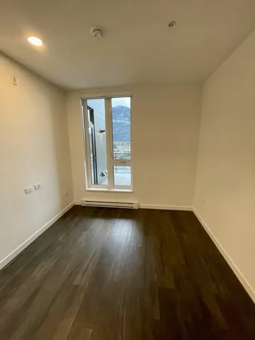 Empty room featuring dark wood-style floors, recessed lighting, and a baseboard radiator
