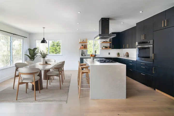 Kitchen with stainless steel oven, open shelves, a kitchen island, light countertops, and island range hood