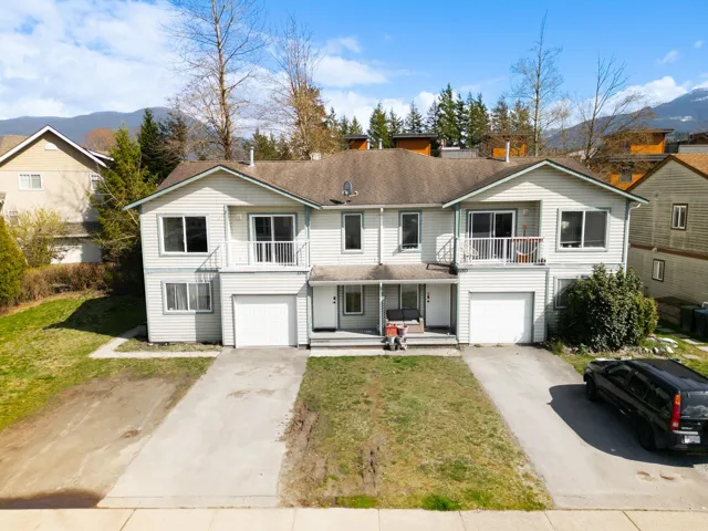 View of front of home featuring concrete driveway, a balcony, a mountain view, and an attached garage