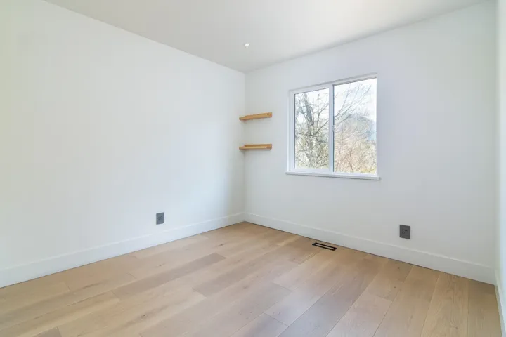 Empty room featuring light wood-style floors, visible vents, and baseboards