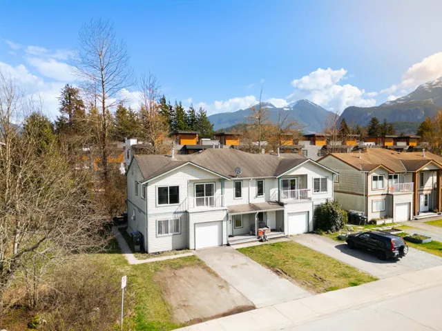 View of front of home featuring concrete driveway, a residential view, a balcony, a mountain view, and an attached garage