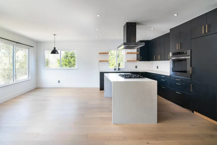 Kitchen featuring open shelves, oven, dark cabinetry, island range hood, and a kitchen island