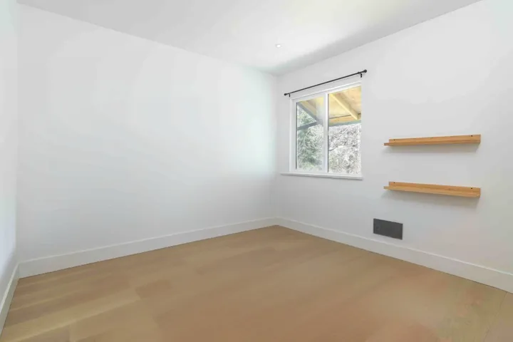 Unfurnished room featuring visible vents, baseboards, and wood finished floors