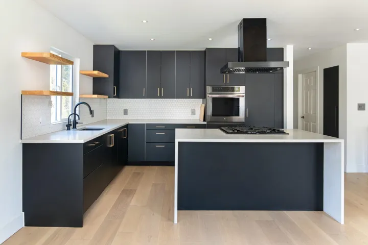 Kitchen with a center island, open shelves, oven, range hood, and a sink