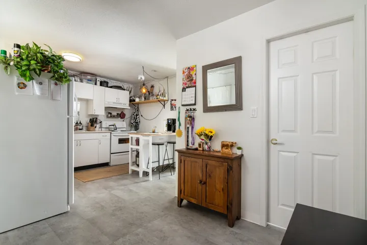 Kitchen featuring white cabinets, open shelves, light countertops, white appliances, and under cabinet range hood