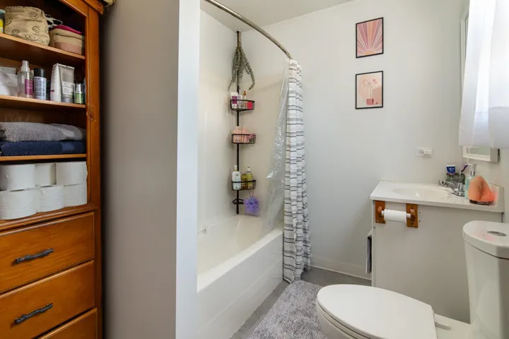 Full bath featuring shower / bath combo with shower curtain, vanity, baseboards, and toilet