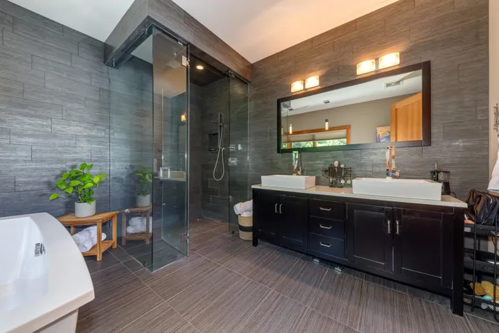 Full bath with double vanity, a stall shower, tile walls, a bathtub, and tile patterned flooring