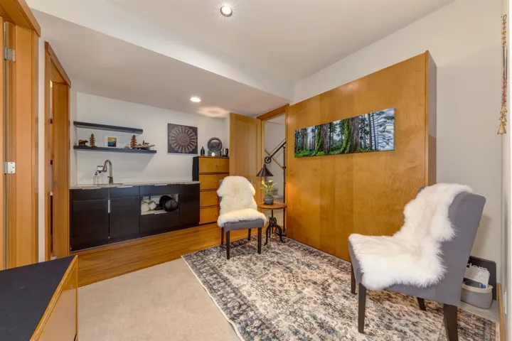 Living area with wet bar, wood finished floors, and recessed lighting