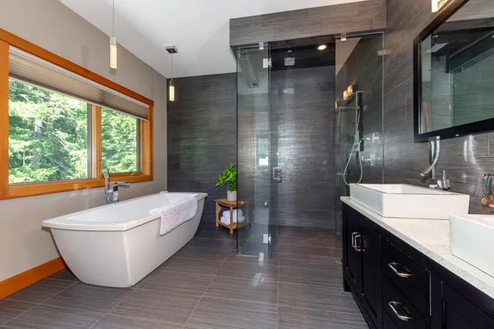 Bathroom with double vanity, a stall shower, a soaking tub, tile patterned floors, and tile walls