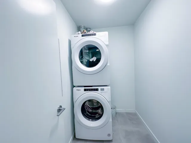 Washroom featuring stacked washer / dryer and baseboards