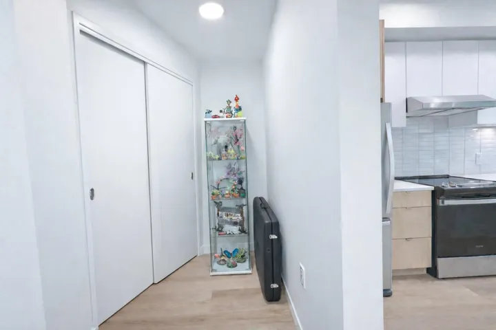 Hall with light wood finished floors and recessed lighting