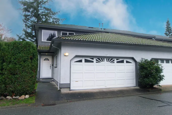 View of front of house featuring a garage, stucco siding, and a tile roof