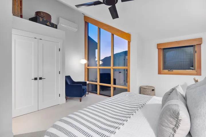 Bedroom with an AC wall unit, carpet, and ceiling fan