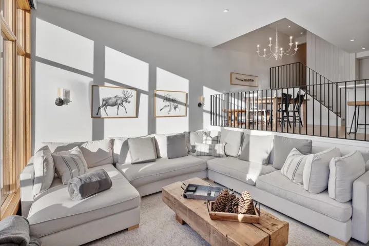 Carpeted living room with an inviting chandelier, a high ceiling, stairway, and recessed lighting