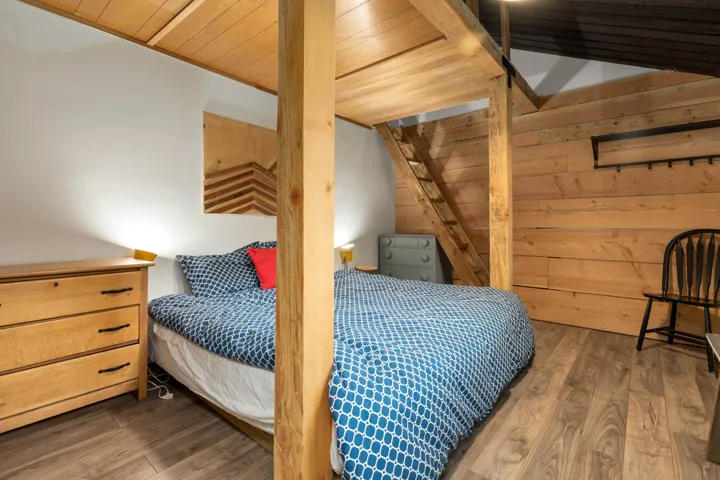 Bedroom with wood finished floors, wooden walls, and wooden ceiling
