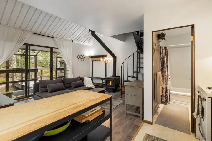 Dining area with a wood stove, stairway, and wood finished floors