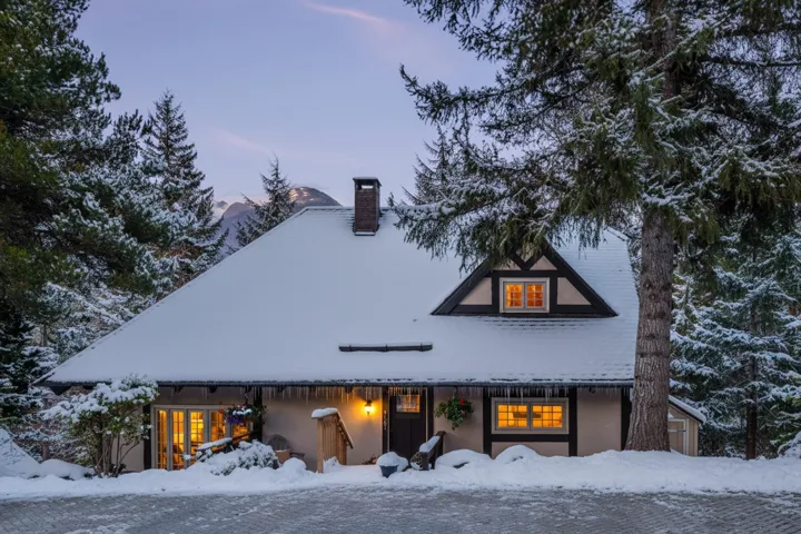 View of front of property featuring a chimney and stucco siding