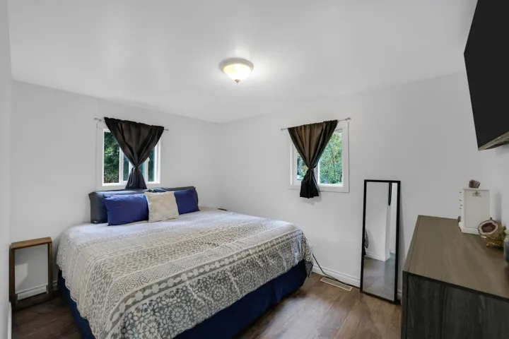 Bedroom featuring dark wood finished floors and multiple windows