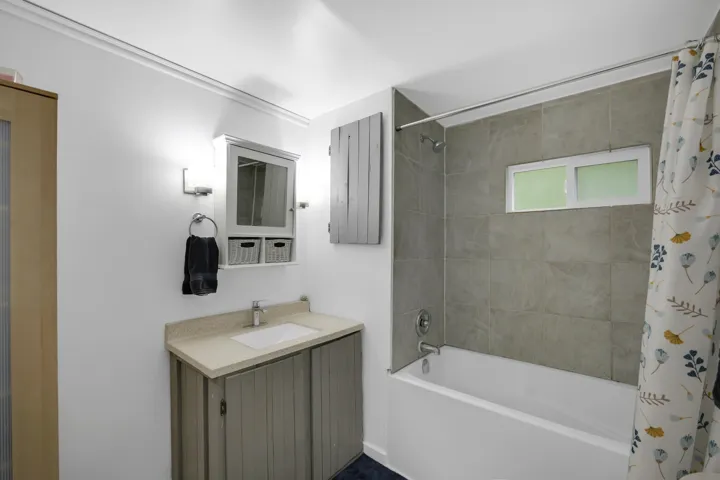 Full bathroom with shower / bath combo and vanity