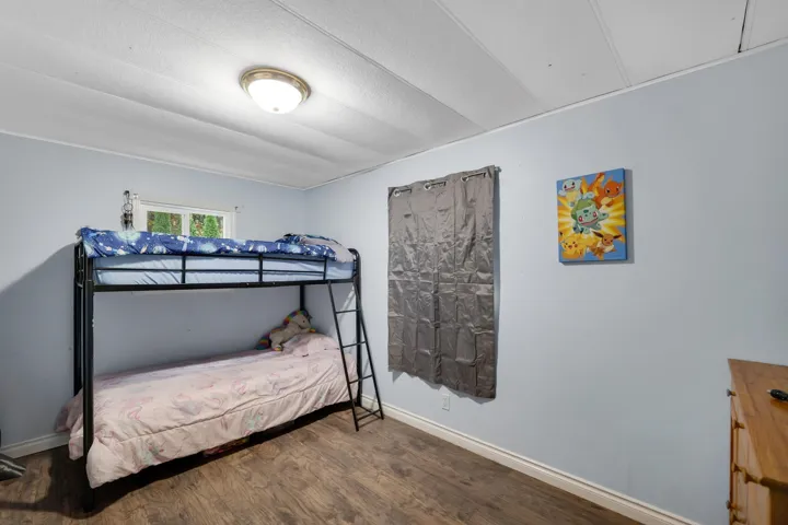 Bedroom with dark wood finished floors and baseboards