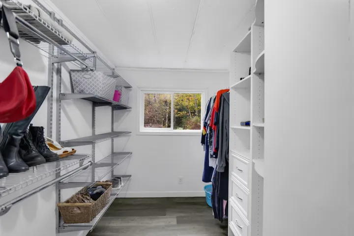 Walk in closet featuring dark wood-style floors