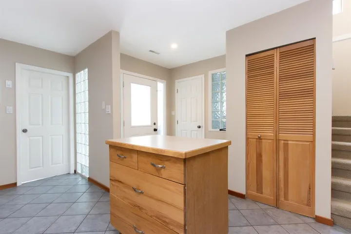 Kitchen featuring a kitchen island, light tile patterned floors, and light countertops