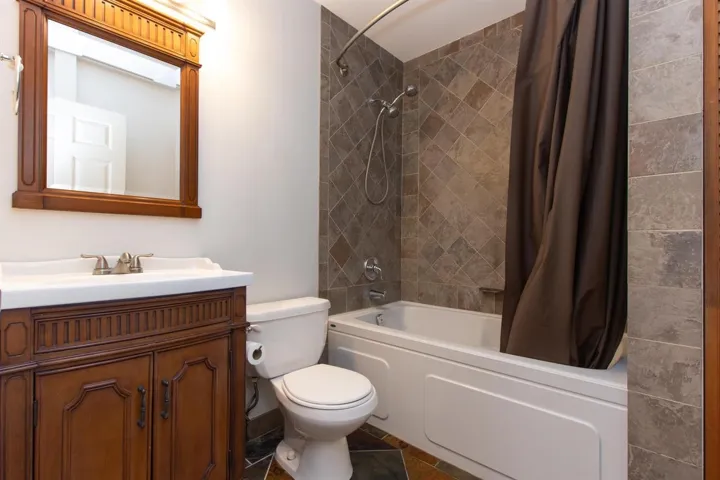 Bathroom with shower / bath combo with shower curtain and vanity