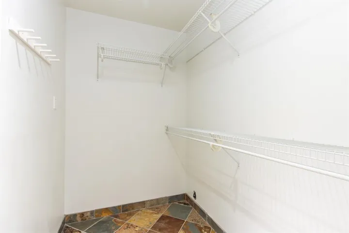 Spacious closet with stone tile flooring
